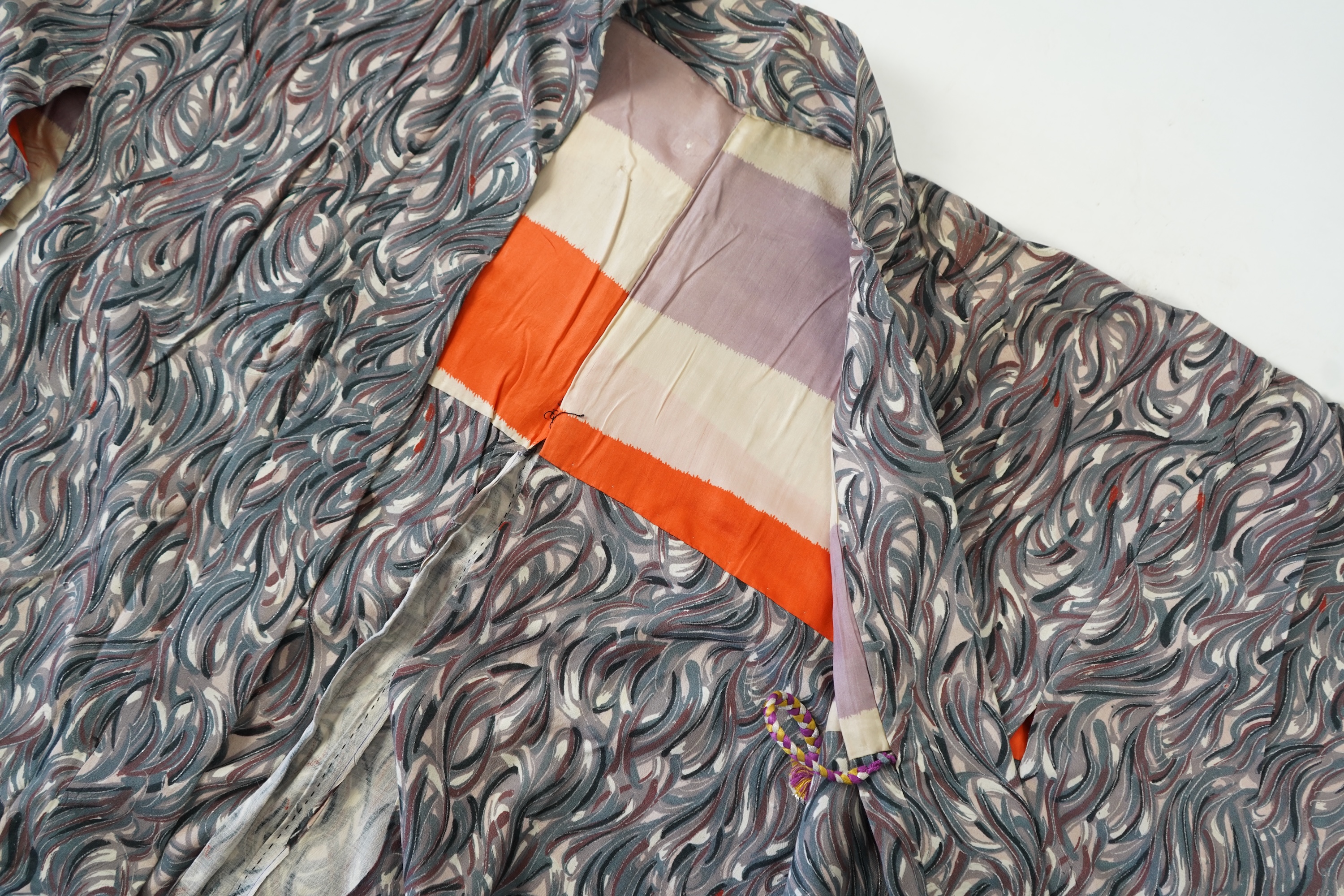 Three Japanese mid 20th century ‘Haori’ printed silk jackets. One red with brightly coloured lining and rust brown floral silk lining. All with large kimono sleeves. Grey patterned Haori, 79cm long., Condition - good